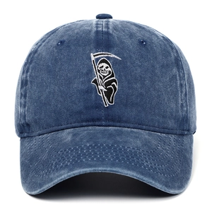 Close-up of Grim Reaper embroidery on washed navy denim baseball cap fabric