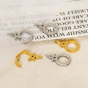 Macro detail of 18K gold and silver plated DIY jewelry clasp connectors on textured paper