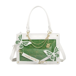 Close-up of white leather tote with green glitter panel and gold spider web pattern