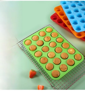 Detailed view of 24-cup silicone muffin pan in vibrant colors with freshly baked cakes
