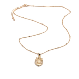 Macro shot of gold-plated horseshoe pendant necklace with clear crystals and beads