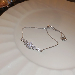 Detailed view of zircon flower bracelet with adjustable bolo clasp on white plate