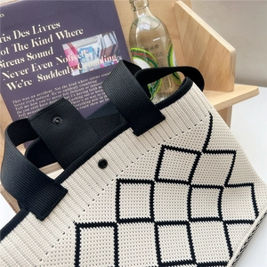 Détail du sac cabas en tricot avec lignes géométriques et fermeture par bouton-pression