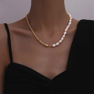 Detail of baroque pearl and golden twisted rope chain necklace on model collarbone