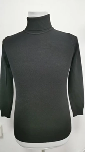 Detailed view of black slim-fit turtleneck sweater showing fine knitted texture and fabric