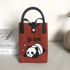 Detail of caramel knit phone bag featuring black panda pattern and button closure