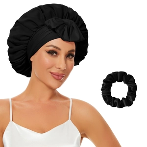 Detail of black satin sleep cap with bow tie and matching hair scrunchie set
