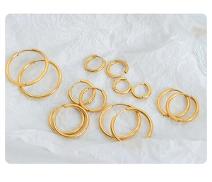 Detailed view of polished gold-plated titanium steel hoop earrings in various sizes