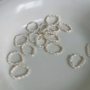 Baroque freshwater pearl elastic rings set with silver beads in a ceramic bowl