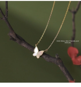 Macro shot of S925 silver butterfly pendant with white mother of pearl on a branch
