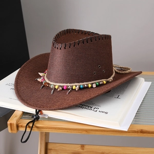 Detail of dark brown cowboy hat with decorative ethnic beads, shells, and feather charms