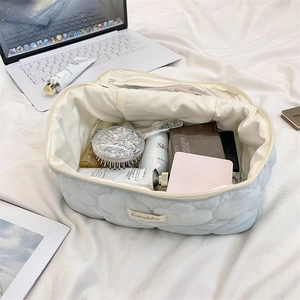 Detail view of large cloud quilted wash bag featuring internal mesh organizers and zip