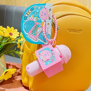 Pink cartoon microphone keychain with cat and donut hanging on a yellow backpack