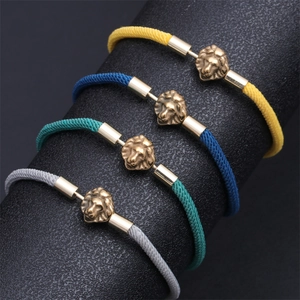 Detail of woven lion head bracelets in four colors on a textured display stand