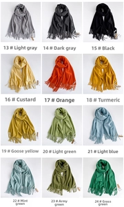 Vista dettagliata con vari colori di sciarpe in finto cashmere con nappe e frange lunghe