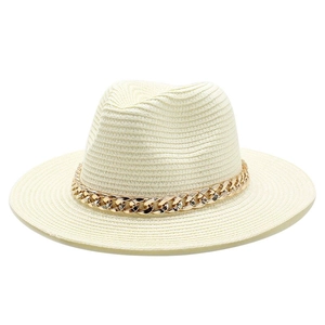 Detail of cream straw fedora hat featuring a chunky gold metal chain accent band
