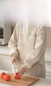 Detail of waterproof long-sleeved apron with plush pocket and rabbit print in kitchen