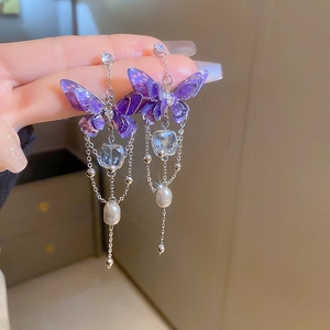 Detail of silver drop earrings with purple crystal butterflies and long tassel pearls