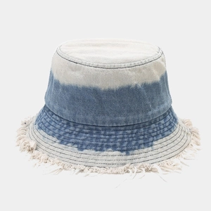 Détail d'un bob en denim délavé dégradé bleu avec des bords effilochés élégants