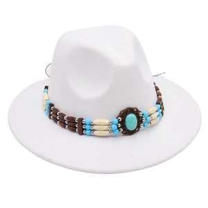 Detail of ethnic fedora hat featuring turquoise bronze ornament and beaded bohemian band
