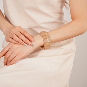Detailed view of an amber acrylic geometric bracelet on wrist with translucent texture