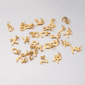 Detail of mirror-polished gold stainless steel alphabet pendants with connecting jump rings