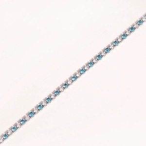 Detail of silver tennis bracelet with alternating clear and blue cubic zirconia stones