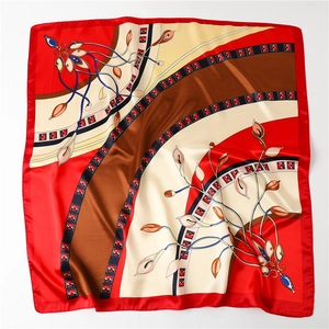 Detail of red floral satin scarf with retro botanical patterns and silk-like luster