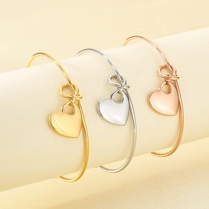 Polished heart pendant open bangles in gold, silver, and rose gold stainless steel finishes