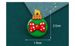 Macro shot of 2.5cm green resin cartoon charm with red polka dot bow for DIY crafts