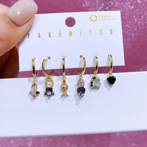 Close-up of a 6-piece gold earring set with colorful zircons and cute charms
