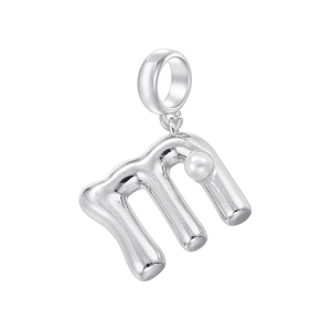 Détail macro d'un pendentif argenté lettre m avec une petite perle blanche centrée