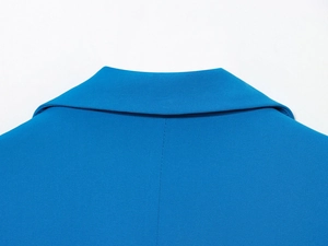 Gros plan du col de blazer bleu roi montrant la texture du tissu en sergé et les détails