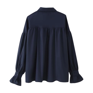 Detail view of the back pleats and ruffled cuffs on this elegant navy blue women shirt