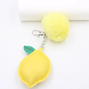 Lemon PU leather keychain with yellow pom pom and green leaf detail on white background