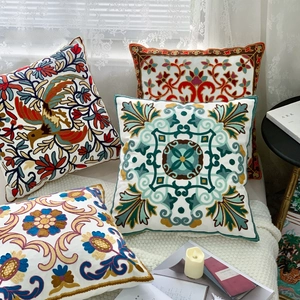 Detailed view of embroidered throw pillow covers with pastoral ethnic floral and textured patterns.