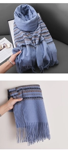 Detailed view of blue plaid cashmere-like scarf with fringe tassels and soft fabric texture