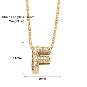 Macro view of gold-plated 'F' letter pendant necklace with sparkling cubic zirconia inlay