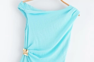 Détail de la robe dos nu bleu lagon avec texture en coton lin et boucle dorée ondulée