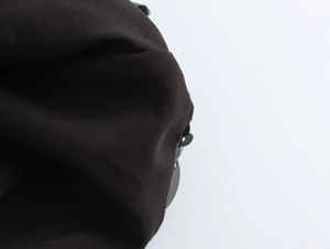 Detail of black fabric texture with dark sequin trim on a sexy bodycon maxi dress