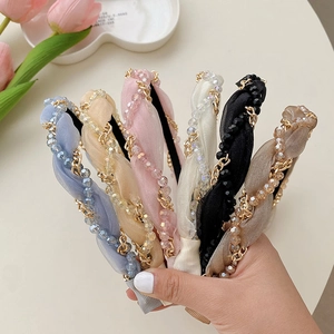 Detailed view of woven headbands with pearl chains in various elegant pastel colors
