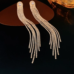 Vue détaillée de boucles d'oreilles pendantes dorées avec oxydes de zirconium brillants