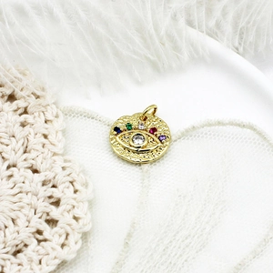 Detailed view of gold evil eye charm pendant with multi-color zircons on elegant setting