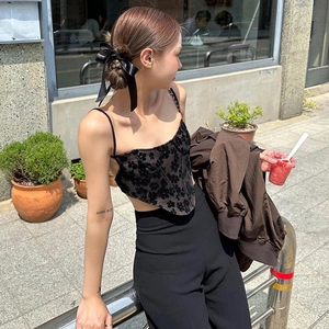 Elegant black ribbon bow hair clip worn by a woman with an updo hairstyle in a city setting