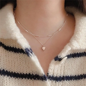 Close-up of a double-layered 925 silver beaded necklace with a geometric diamond pendant