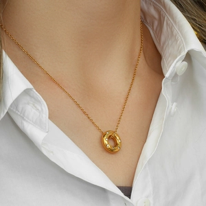 Close-up of 18K gold plated donut necklace with sparkling crystals on female model
