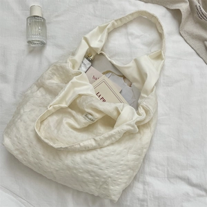 Detail view of large cream tote bag showing waffle texture fabric and spacious interior