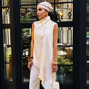 Women's white sleeveless mock neck top with draped front and elegant satin finish