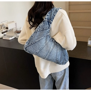 Sac bandoulière en denim bleu porté par un mannequin montrant le style et la coupe