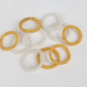 Close-up of golden and silver spring massage rings for finger acupressure therapy